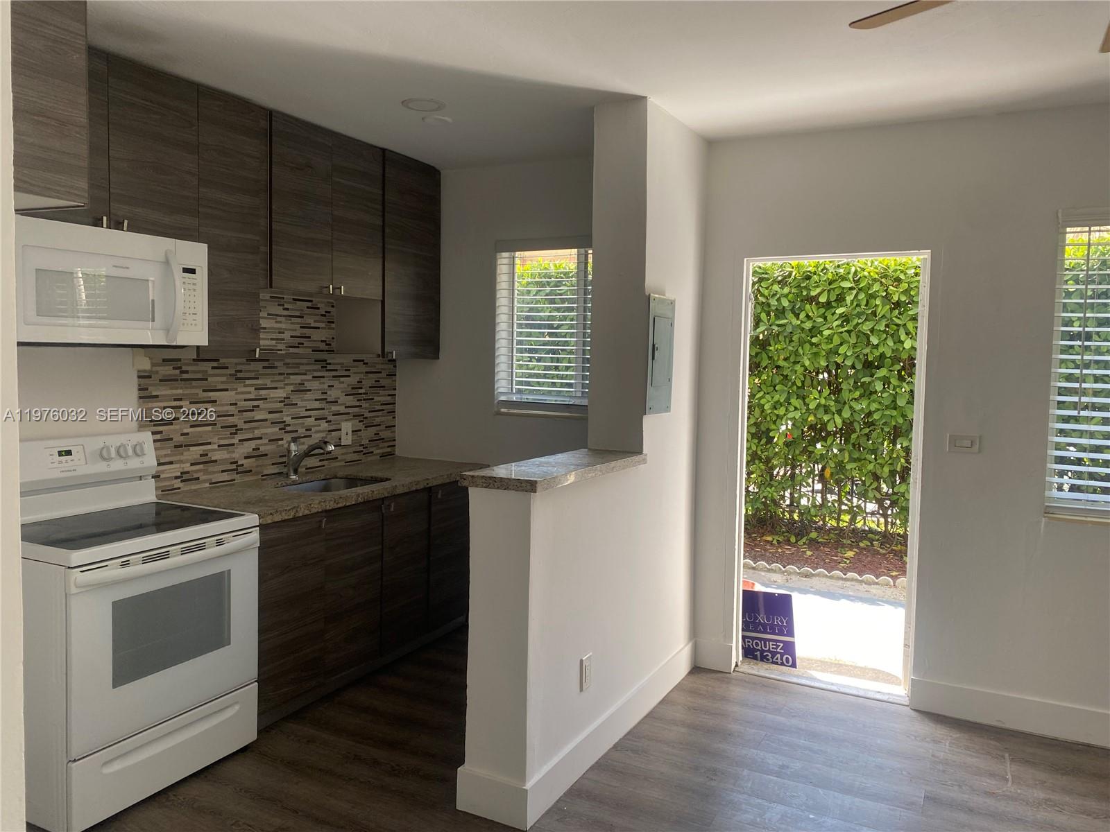 a kitchen with a stove a sink and a window