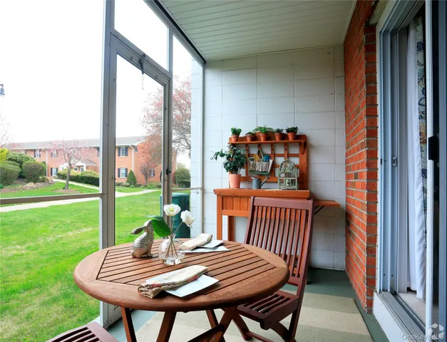 a view of a porch with a table chairs and a yard