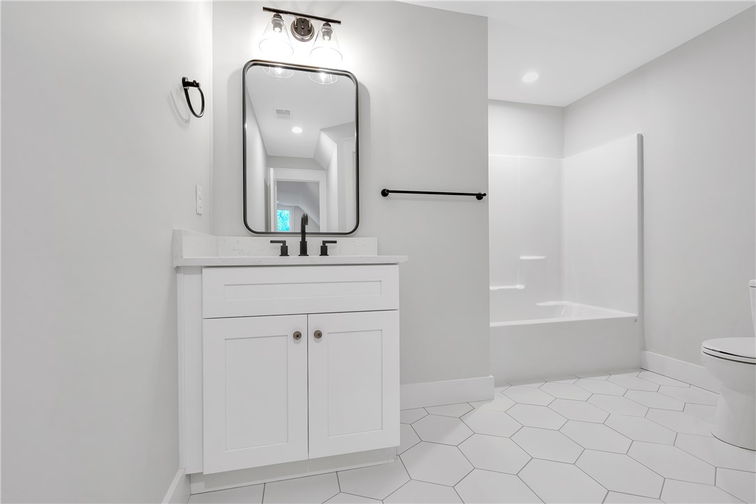 4554 Flat Rock Road Iva, SC 29655 - Photo 27 of 32 A well-appointed bath boasts sleek white cabinetry, a contemporary mirror, and distinctive hexagonal tiled flooring.