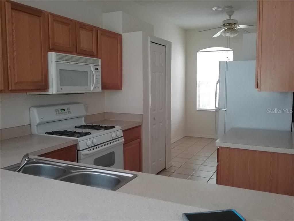 6246 Blue Runner Court Lakewood Ranch, FL 34202 - Photo 4 of 13 a kitchen with granite countertop a stove and a sink