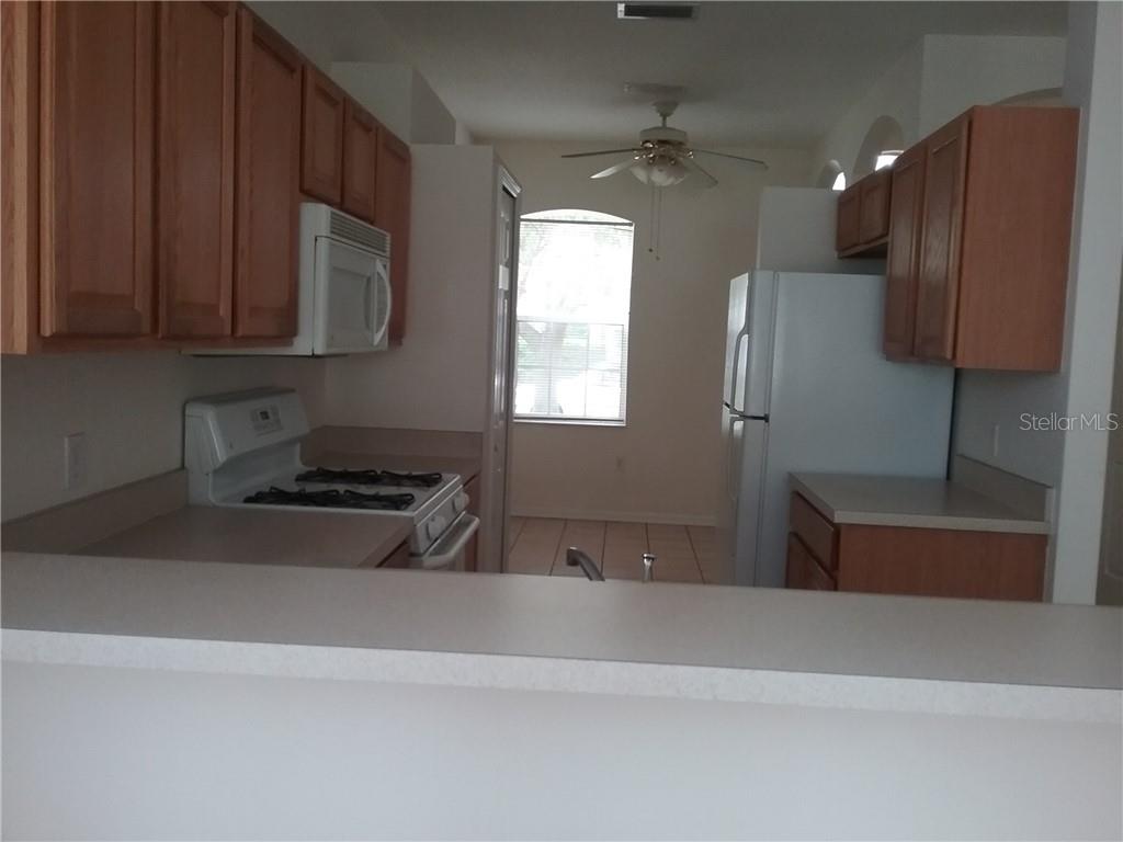 6246 Blue Runner Court Lakewood Ranch, FL 34202 - Photo 5 of 13 a kitchen with stainless steel appliances granite countertop a refrigerator and a stove
