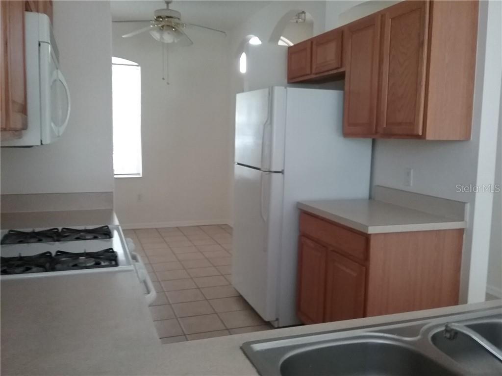 6246 Blue Runner Court Lakewood Ranch, FL 34202 - Photo 10 of 13 a kitchen with stainless steel appliances granite countertop a refrigerator and a stove top oven