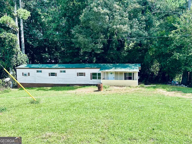 a view of a house with a backyard and a bench