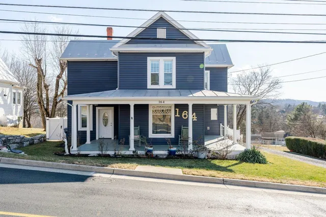 a front view of a house with a garden and plants