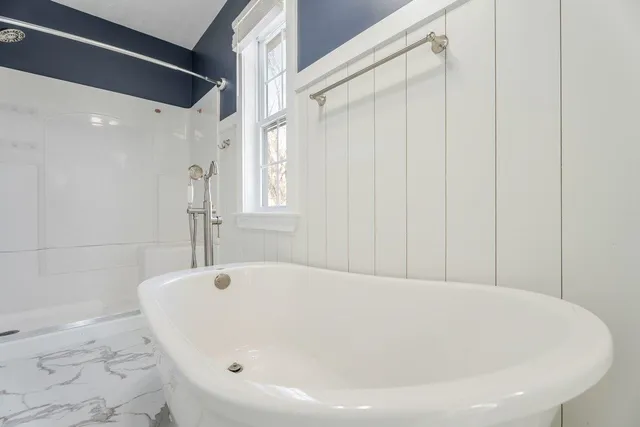 a view of a white house with a large windows and a table and chairs
