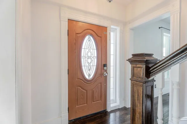 an empty room with wooden floor and window