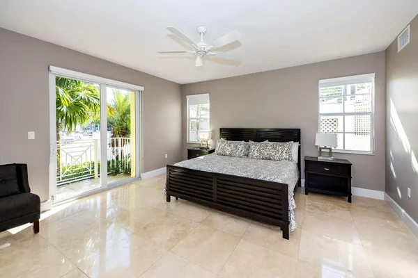 a bedroom with a bed a table and a large window