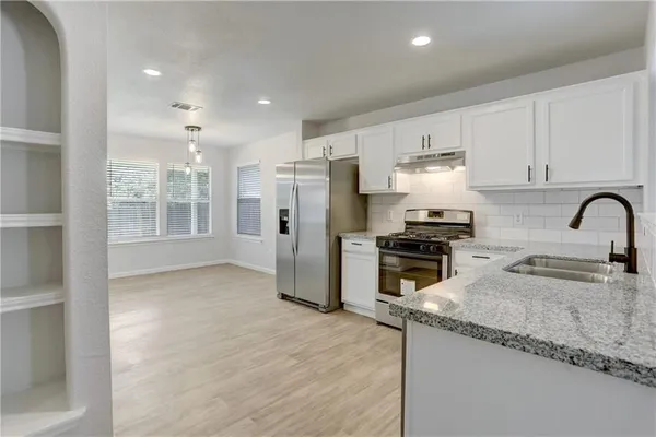 a kitchen with refrigerator and cabinets