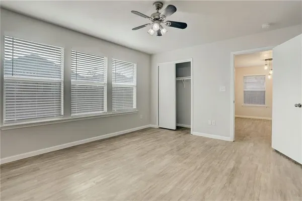a view of an empty room with a window and wooden floor
