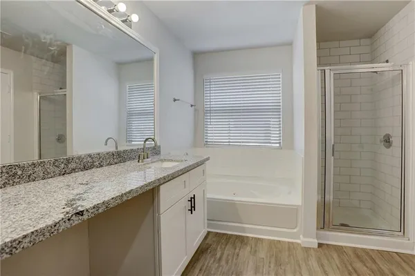 a bathroom with a granite countertop sink a toilet and shower