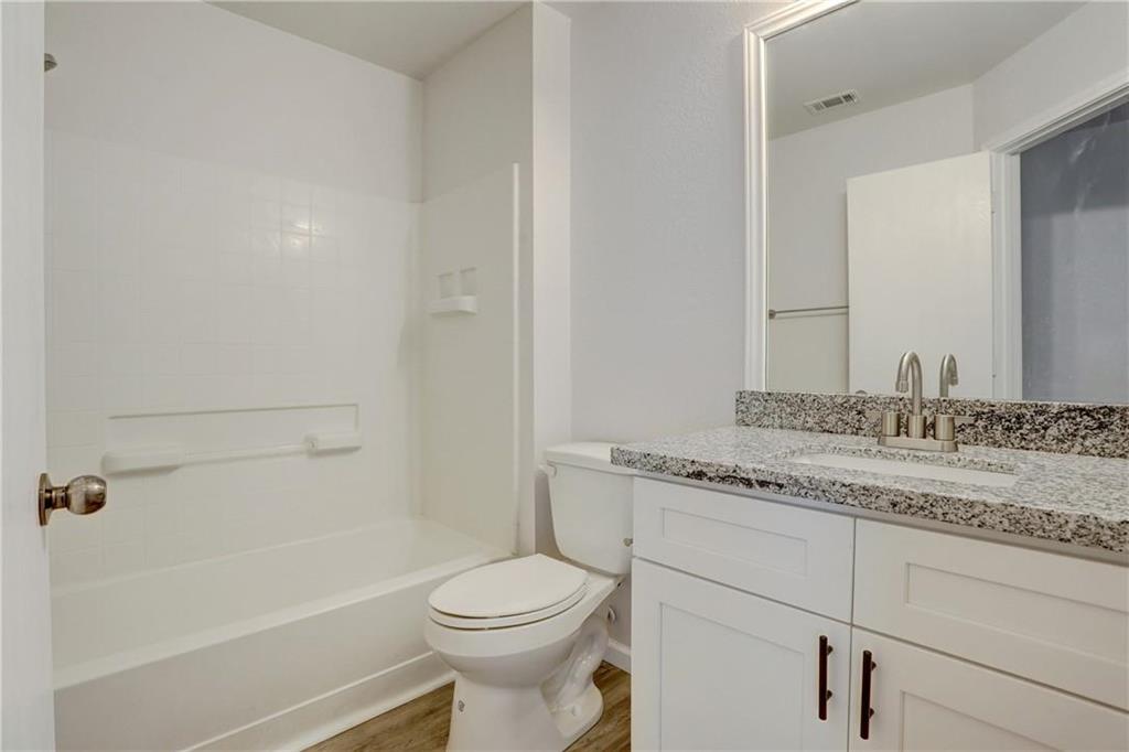 15215 Parrish Lane Austin, TX 78725 - Photo 9 of 10 a bathroom with a granite countertop sink a toilet and bathtub