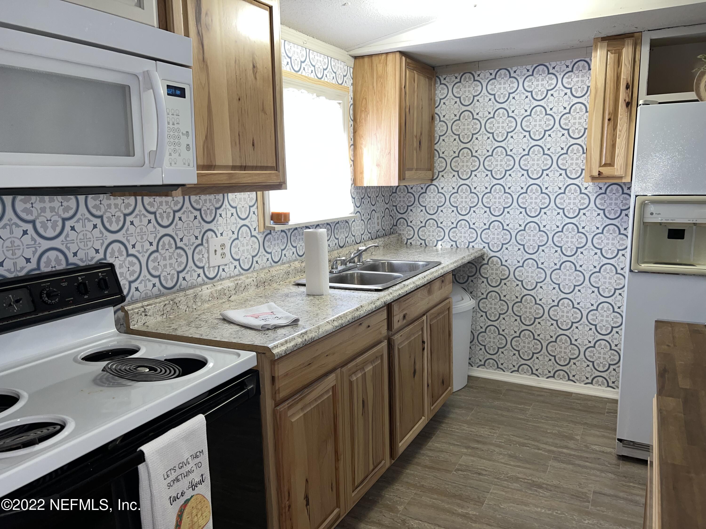 8008 Sunnybrook Road Melrose, FL 32666 - Photo 4 of 17 a kitchen with a sink stove and cabinets