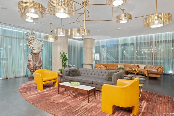a living room with patio furniture and a chandelier