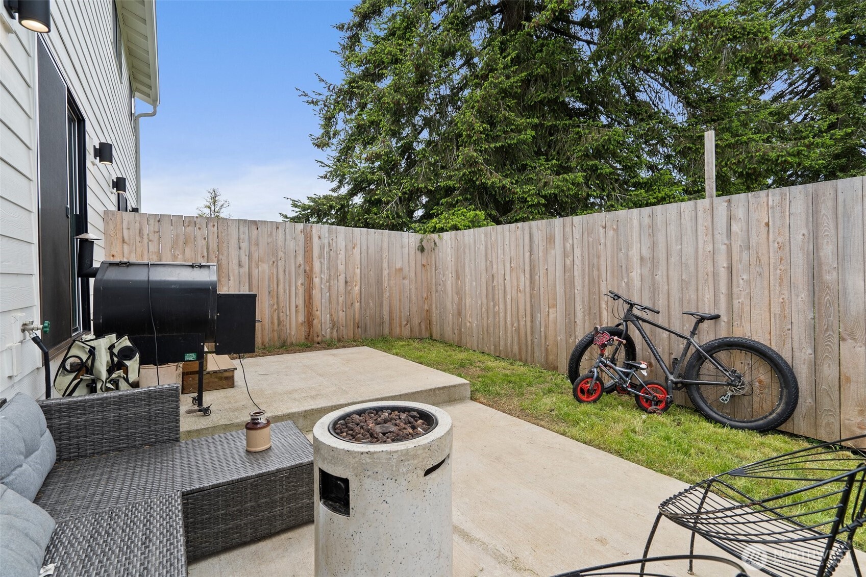 1013 Peach Road, Unit A & B Winlock, WA 98596 - Photo 29 of 30 a view of a patio with table and chairs with a barbeque grill and wooden fence