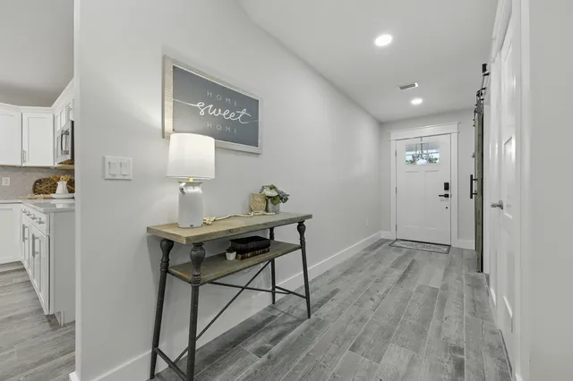 a kitchen with stainless steel appliances granite countertop a sink a stove a refrigerator cabinets and chairs