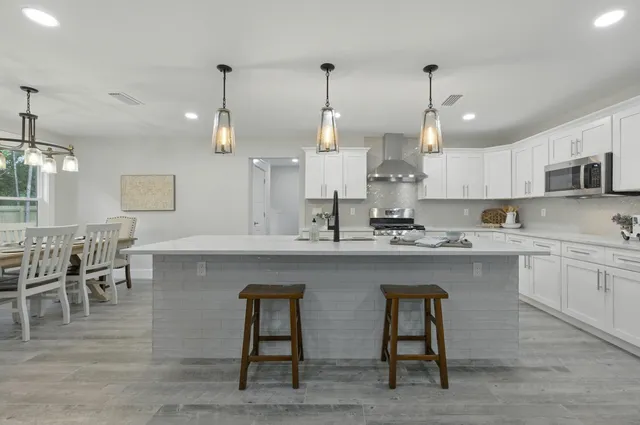 a stove sitting inside of a kitchen with white cabinets