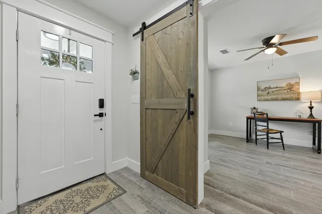 a living room with furniture kitchen view and a chandelier