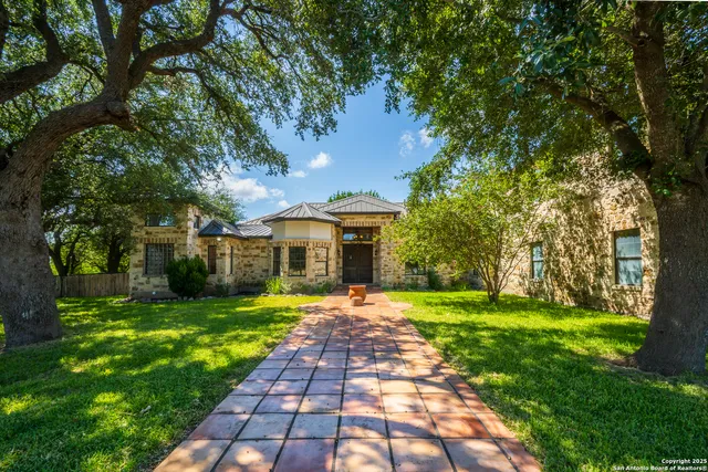 a front view of a house with a yard and trees
