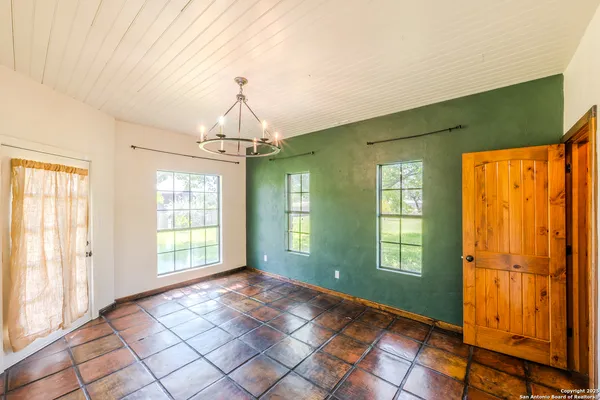 a view of an empty room with window and chandelier