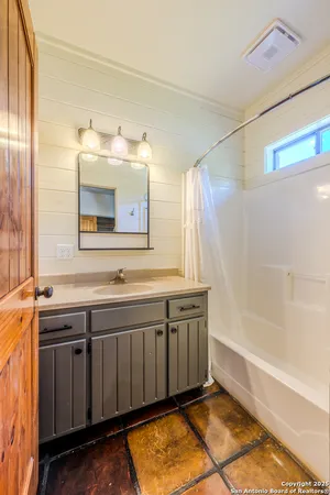 a bathroom with a tub sink and mirror