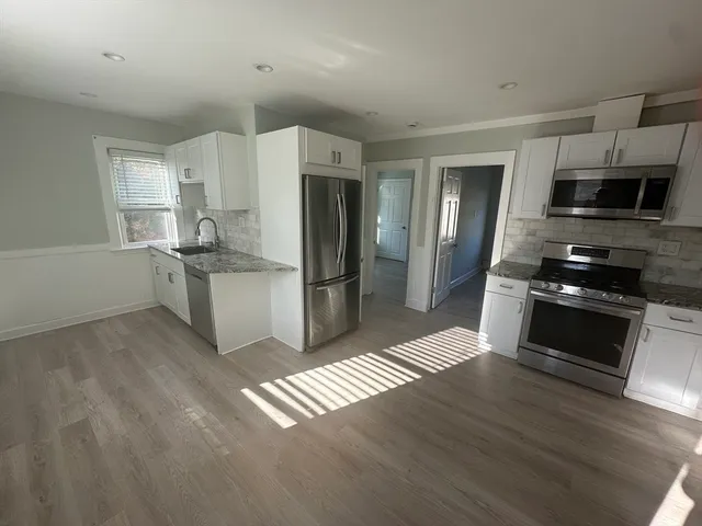 a kitchen with a refrigerator and a stove top oven