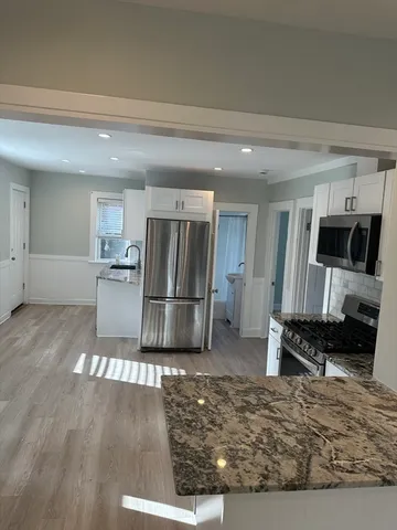 a kitchen with stainless steel appliances granite countertop a refrigerator stove top oven and sink