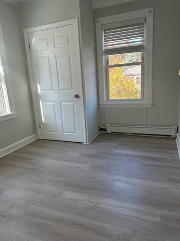 an empty room with wooden floor and a window