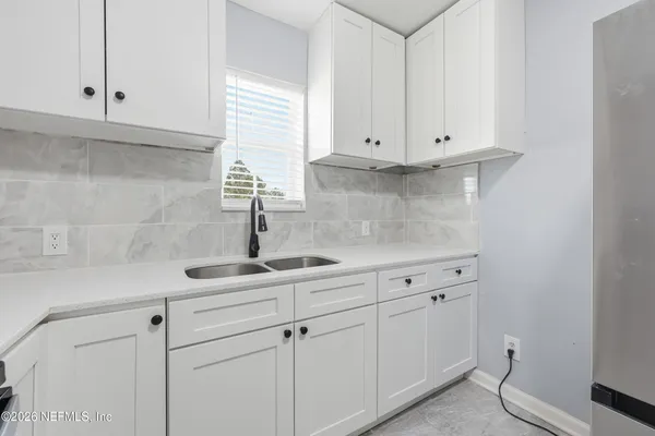 a kitchen with white cabinets and a sink