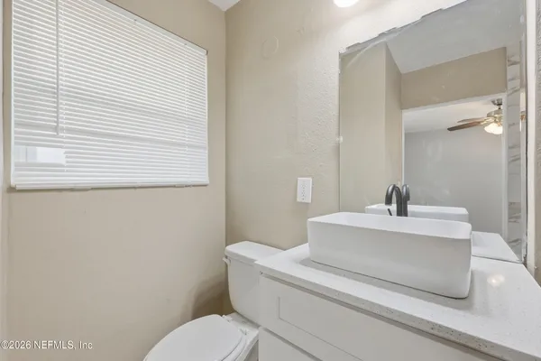 a bathroom with a sink a toilet and mirror