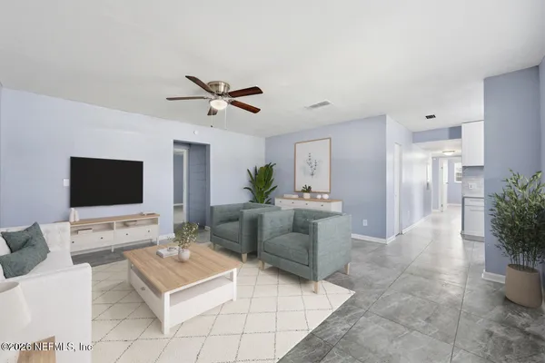 a living room with furniture a flat screen tv and a table