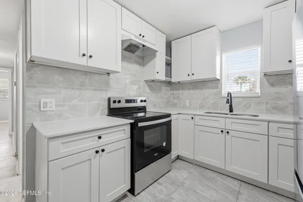 a kitchen with white cabinets and white appliances
