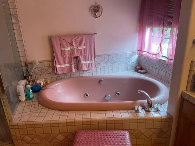 a bathroom with a tub sink and mirror