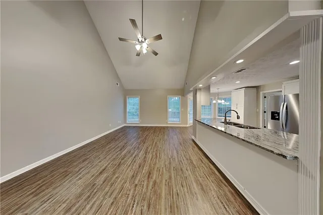 a view of a large kitchen with a wooden floor and stainless steel appliances