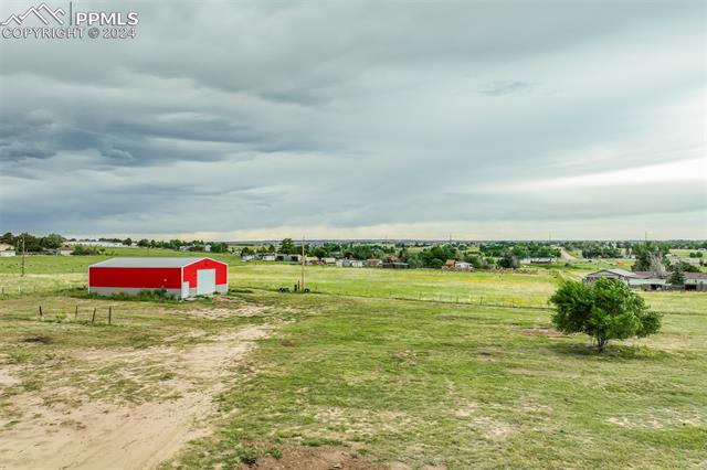 12550 Smith Road Peyton, CO 80831 - Photo 24 of 35 View of yard featuring an outdoor structure and a rural view