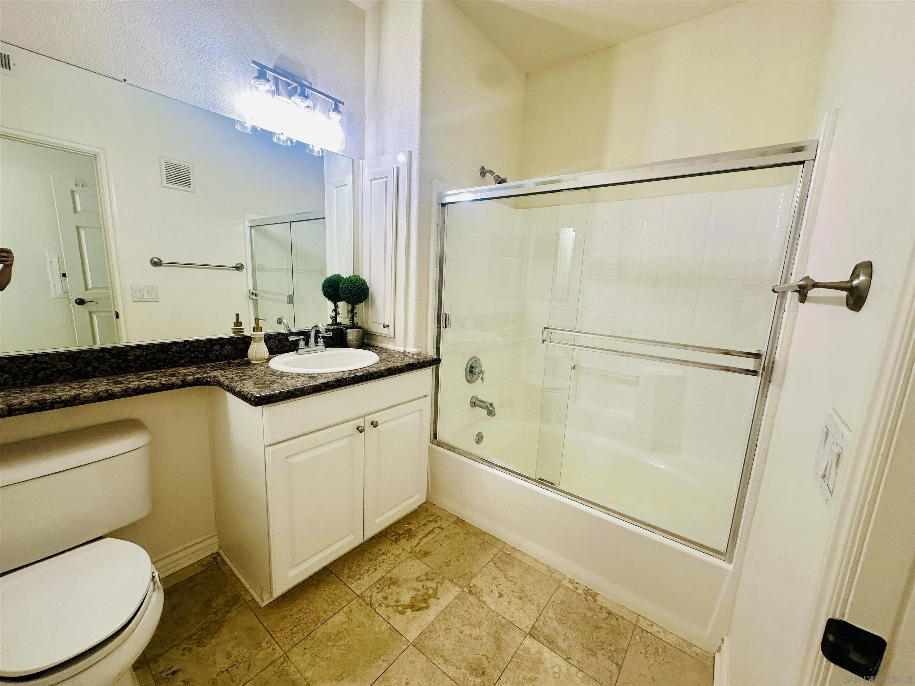 9263 Regents Road, Unit B204 La Jolla, CA 92037 - Photo 14 of 17 a bathroom with a granite countertop sink mirror vanity and toilet