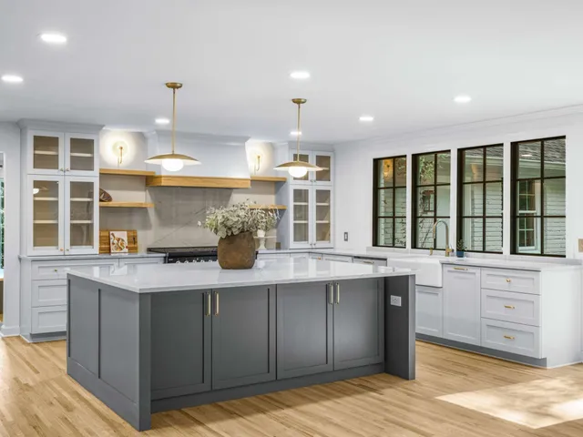 a kitchen with stainless steel appliances kitchen island granite countertop a refrigerator and a sink