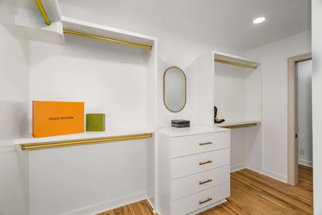 an empty room with wooden floor ceiling fan and windows