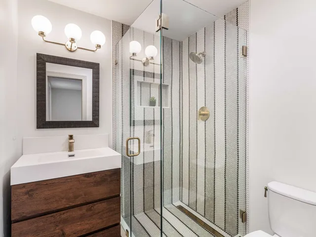a view of a backyard with wooden fence and large trees