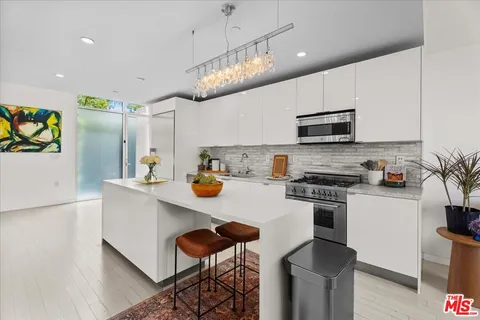 a kitchen with stainless steel appliances a stove refrigerator sink and microwave