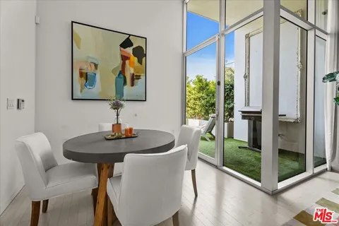 a dining room with furniture and floor to ceiling window