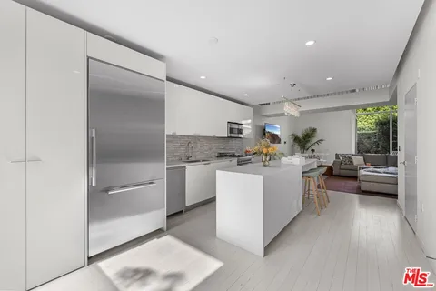 a kitchen with a refrigerator and white cabinets