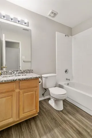 a bathroom with a granite countertop sink a toilet and a bathtub