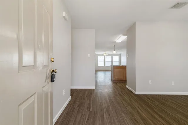 a view of a hallway with wooden floor
