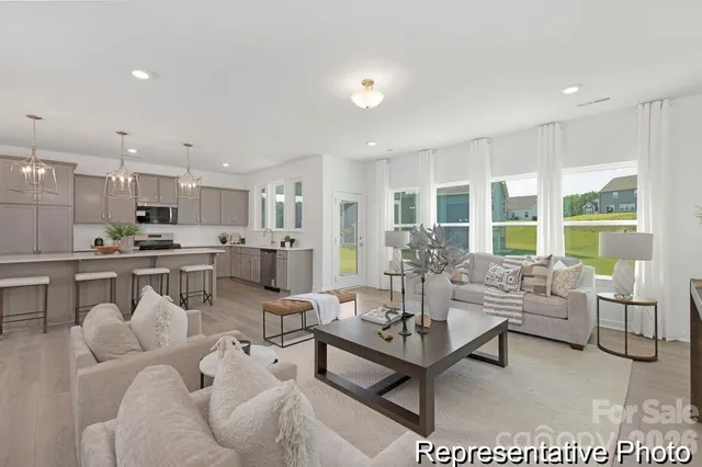 a living room with furniture and a view of kitchen