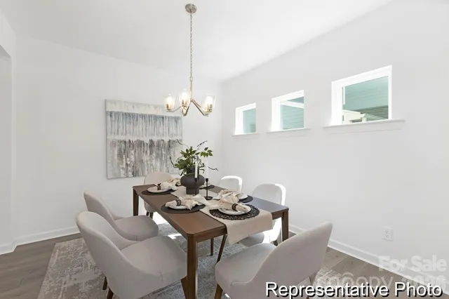 a view of a dining room with furniture a chandelier and wooden floor