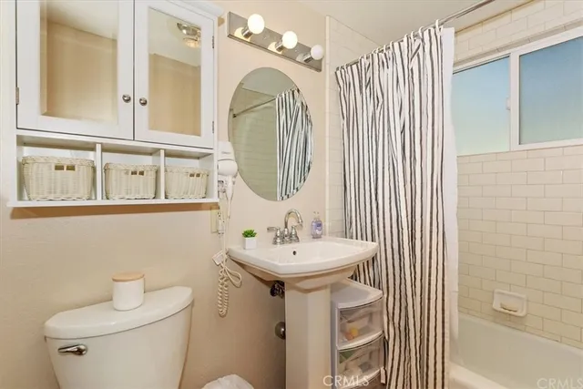 a bathroom with a sink a toilet and mirror