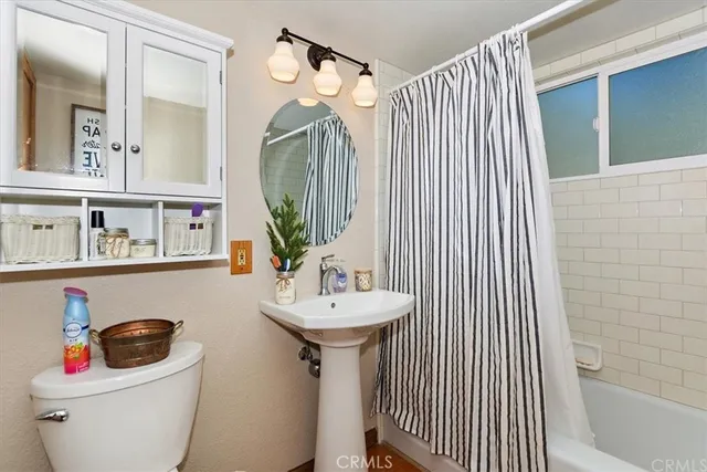 a bathroom with a sink and mirror with toilet