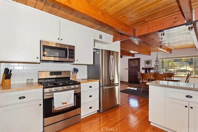 a kitchen with stainless steel appliances a stove microwave and refrigerator