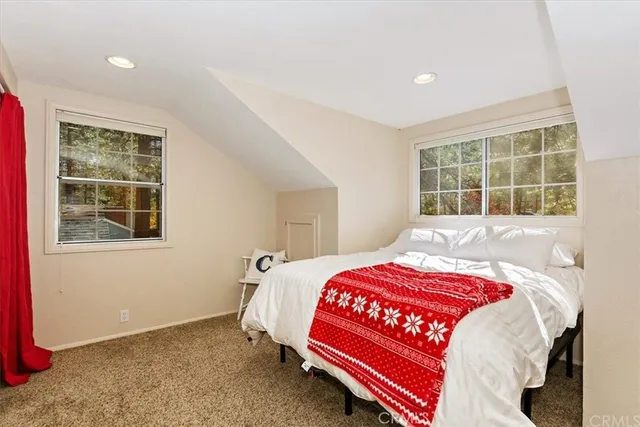 a bedroom with a bed and windows