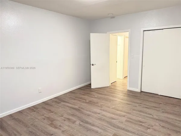 a view of an empty room with wooden floor